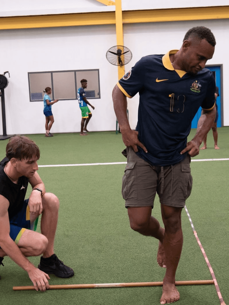 Student coaches athlete on technique in gymnasium