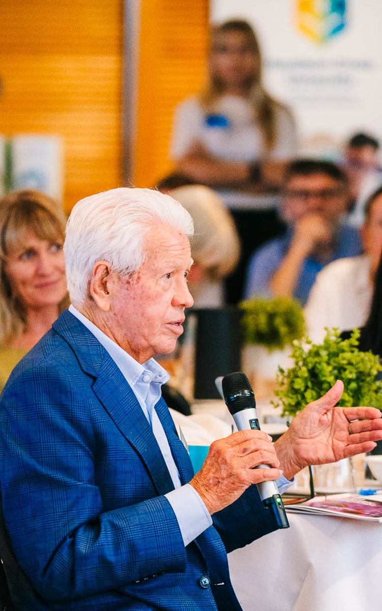 Marcus Blackmore speaking into a microphone at a conference