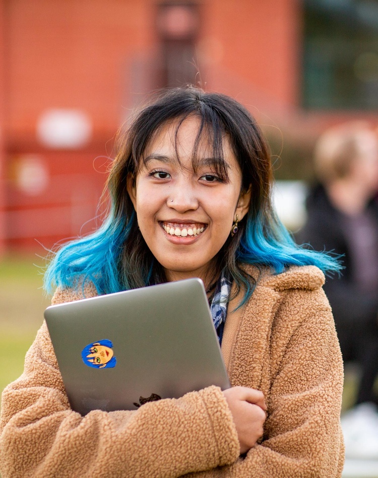 Student portrait holding laptop