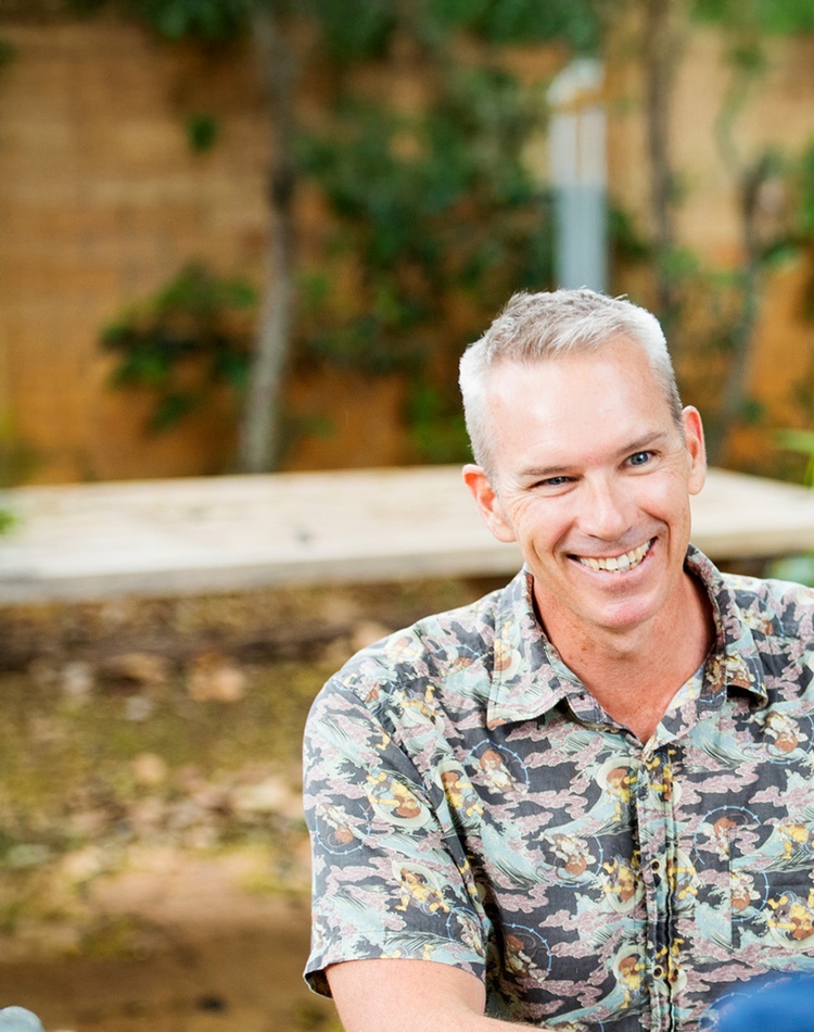 fair haired man smiling at person with back to screen