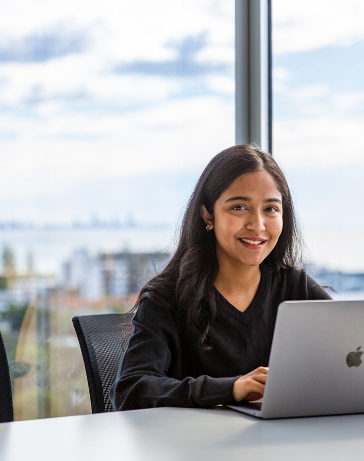 student with laptop - view from gold coast campus in background