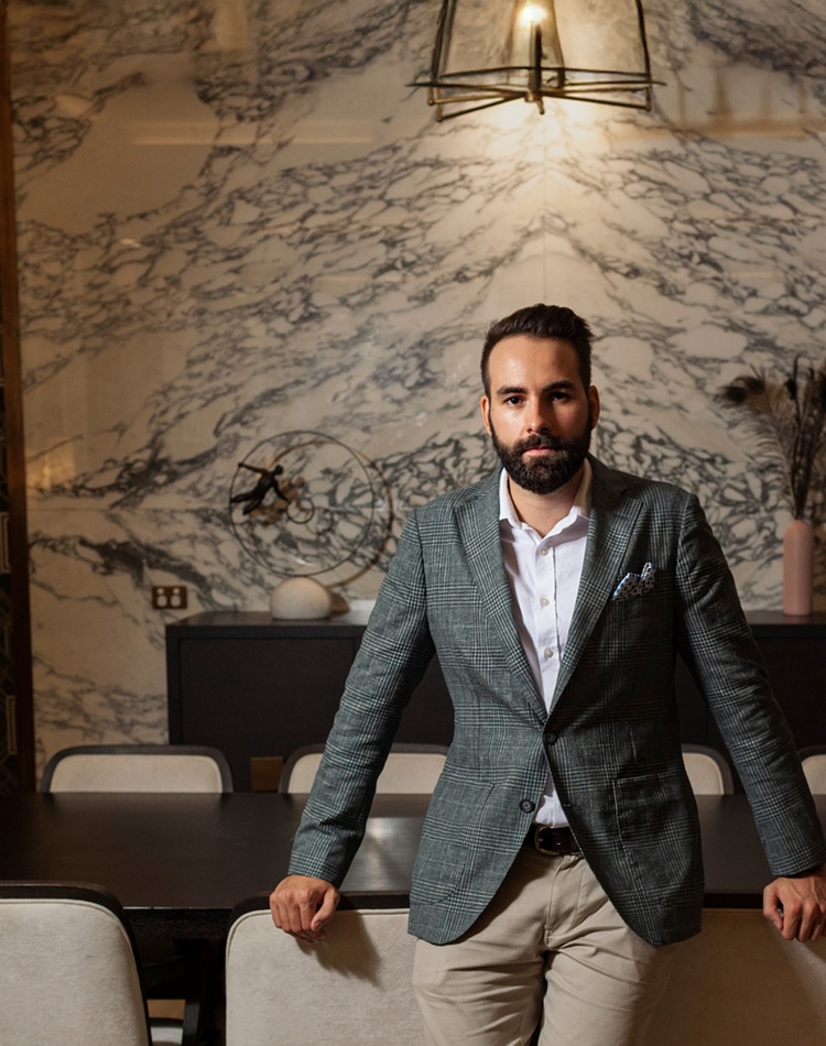 male hotel manager sitting with arms on chair