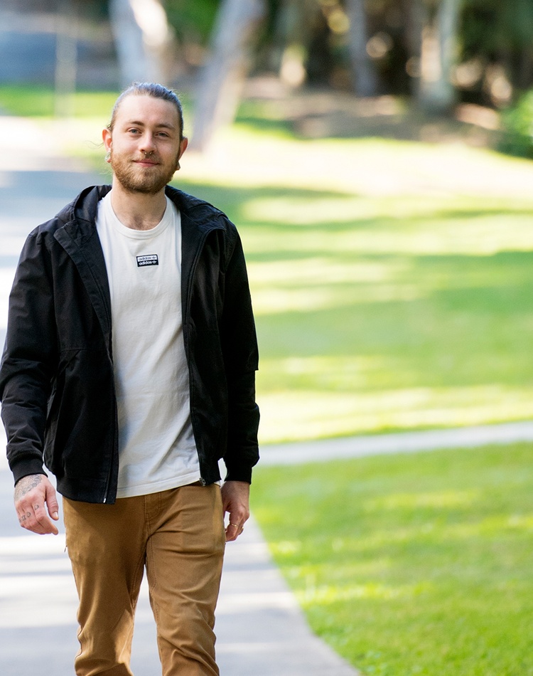 Male student walking on path