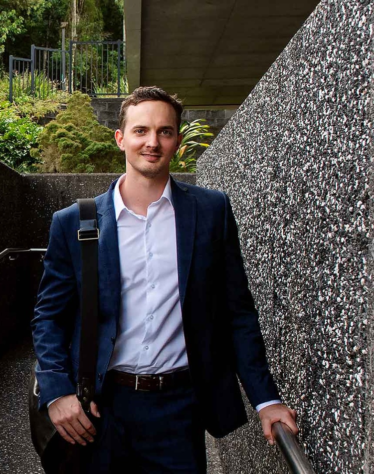 Law student graduate Tom Kershaw standing in front of the Southern Cross University Lismore campus Learning centre
