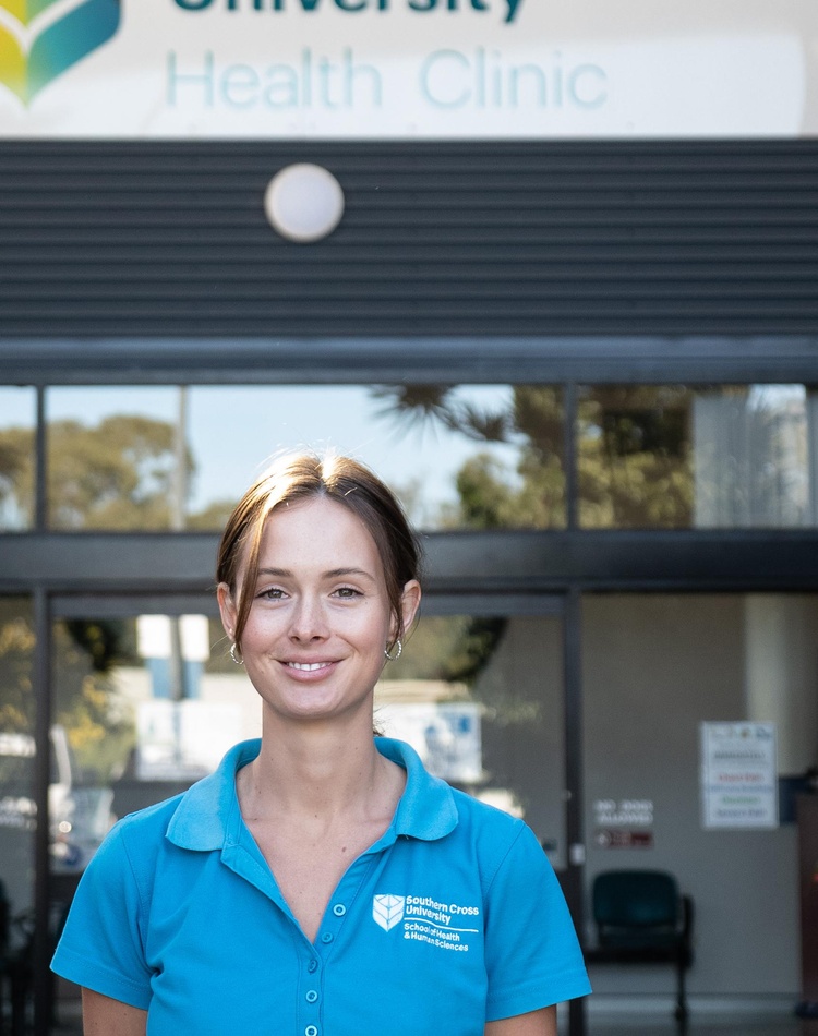 Female student standing in front of Health Clinic