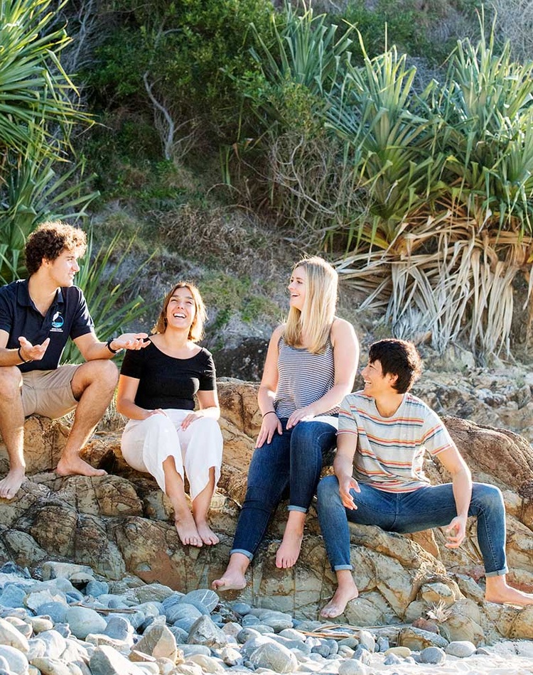 International students sitting on beach