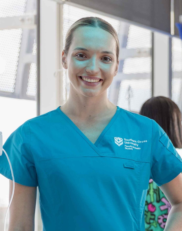 Female smiling at camera in scrubs