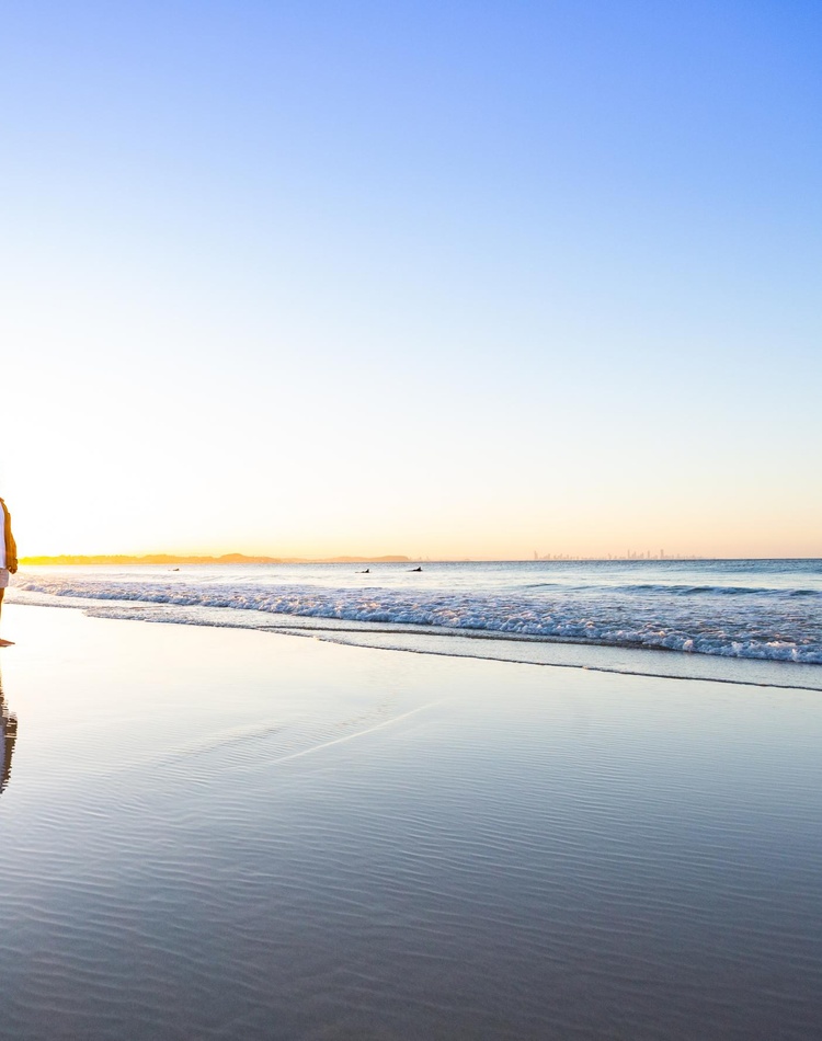 5 people standing at the bench with the sunset behind them