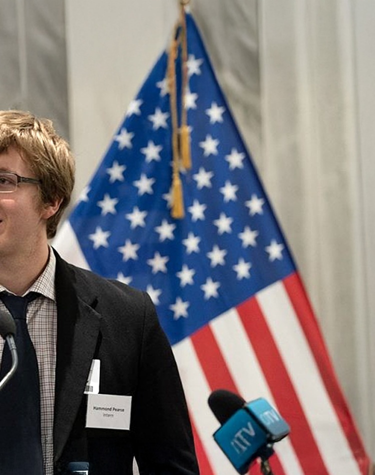 Head and shoulder of man standing in front of flags