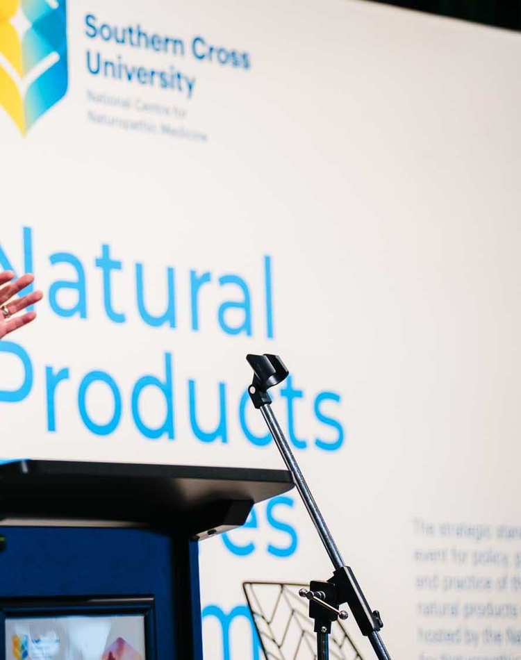A man at a lectern addressing a forum