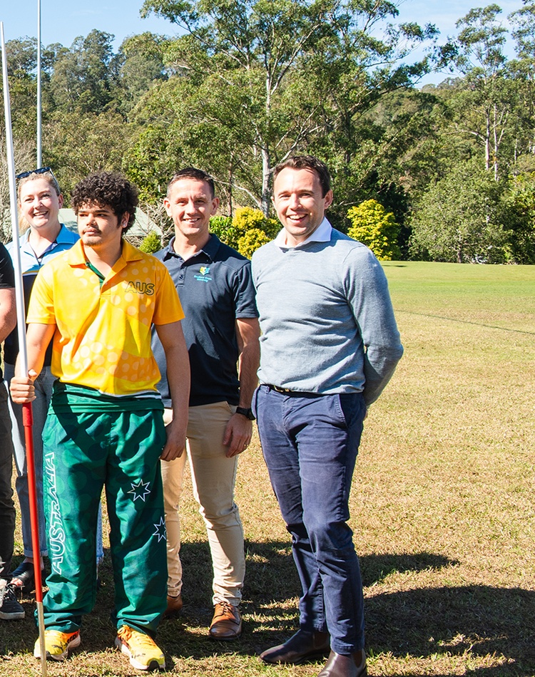 A group of people on a sports oval looking at the camera