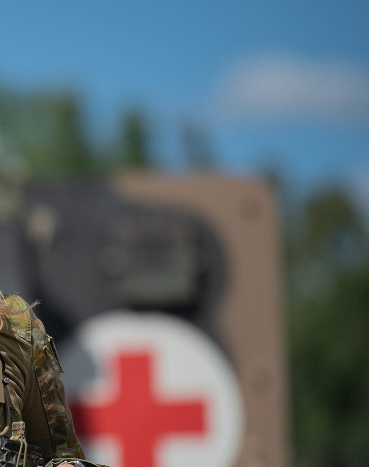 An army nurse standing in front of a medical truck