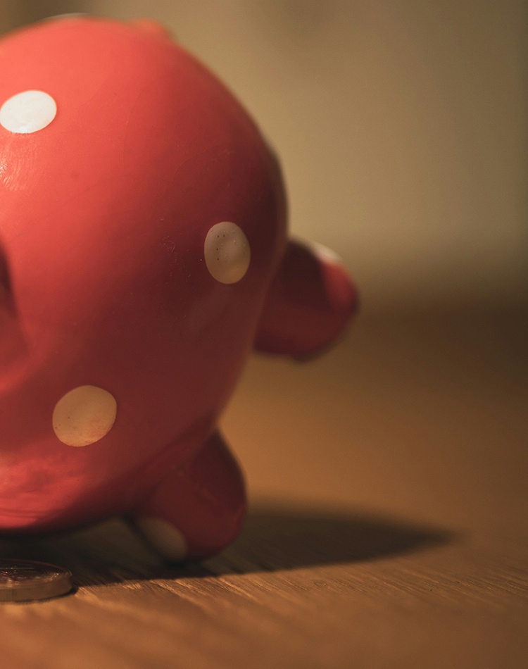 pink pig coin bank on brown wooden table eating coins