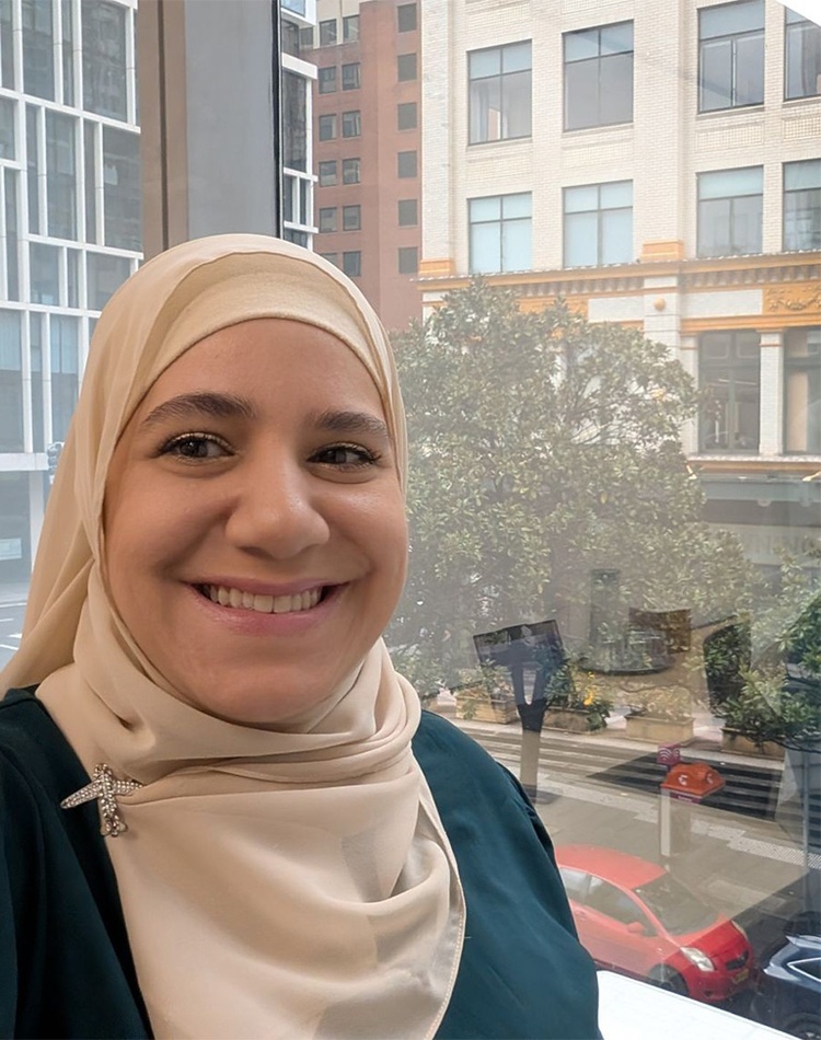 Woman standing in front of a glass window smiling