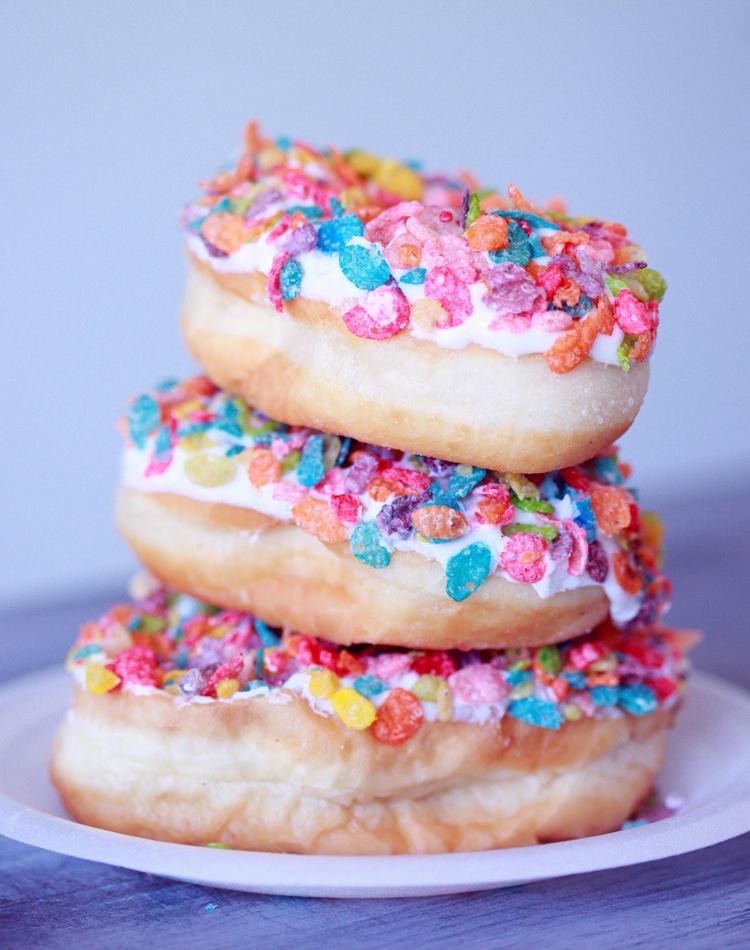 Three doughnuts stacked on a plate