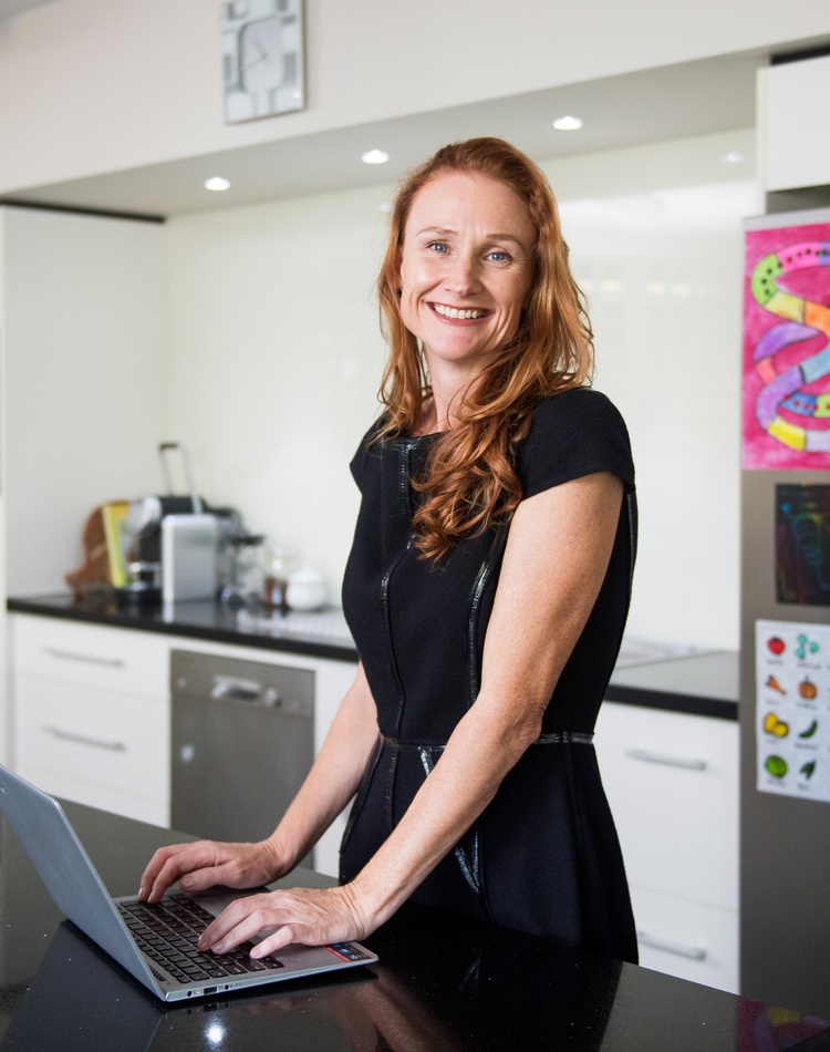 Womena using laptop in kitchen at home