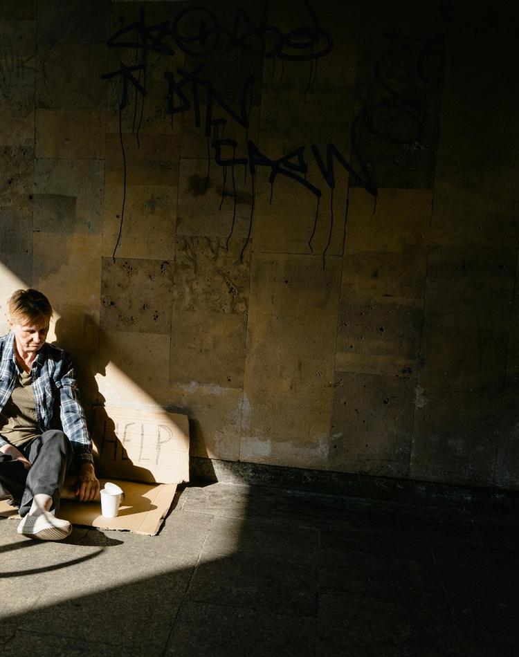 Homeless woman sitting on concrete floor