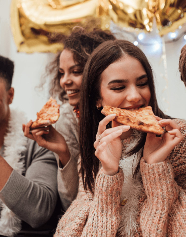 People smiling and eating pizza