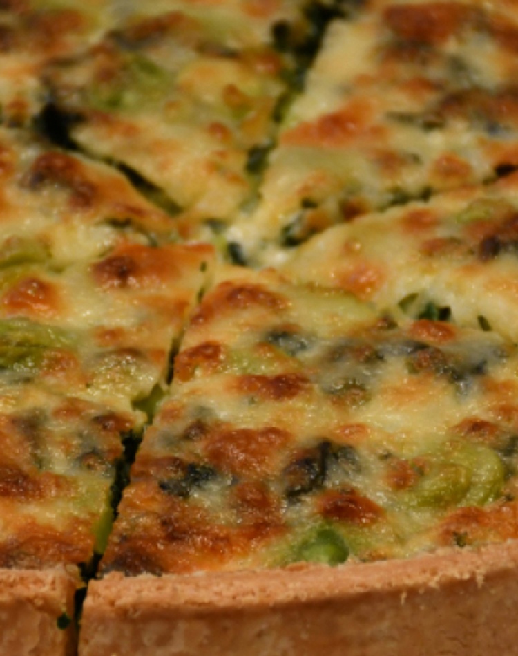 A quiche sliced and served on a plate.