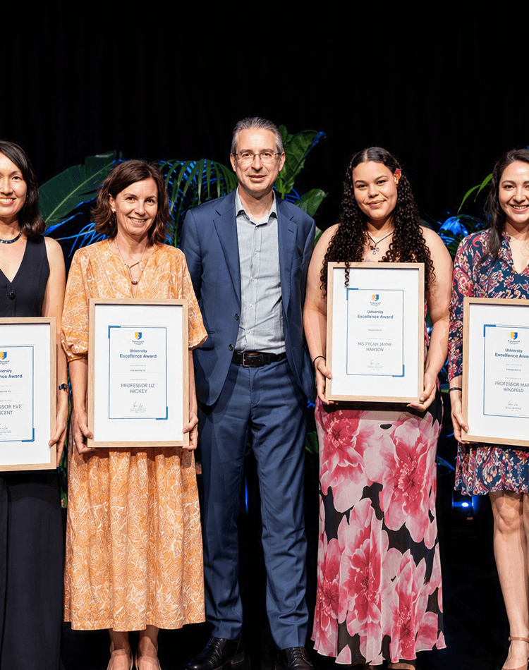 Vice Chancellor standing with students holding certificates