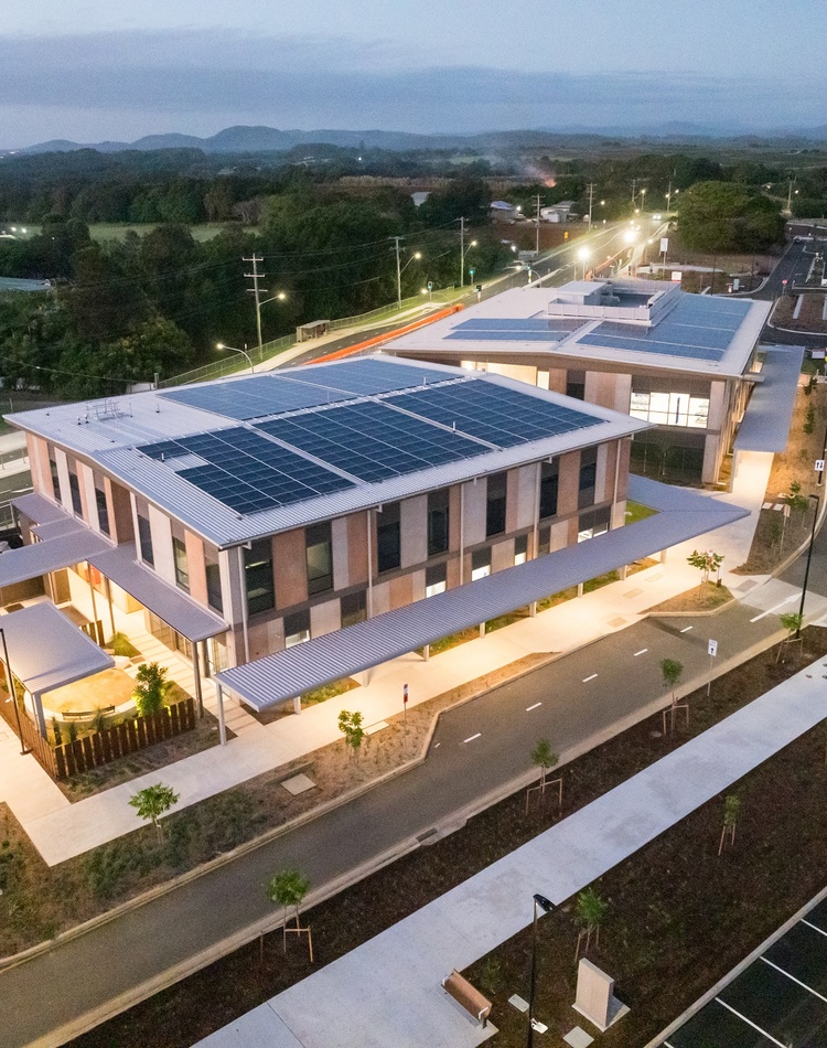 Aerial photograph of a hospital precinct, large illuminated buildings at dusk