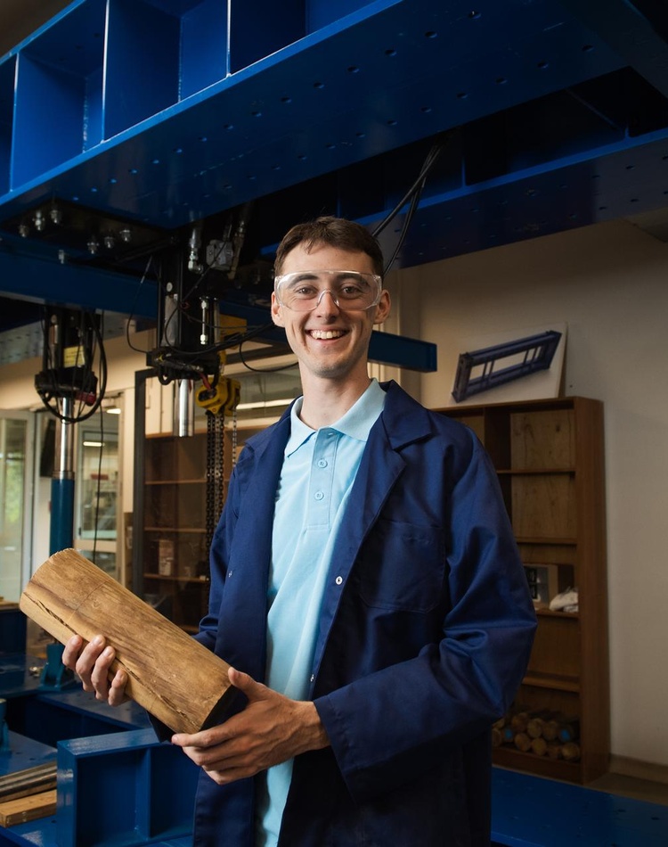 student holding timber in engineering labs