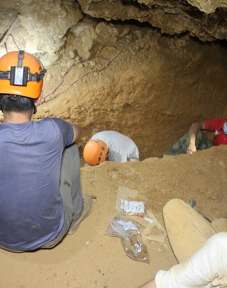 A group of scientists sit in a cave
