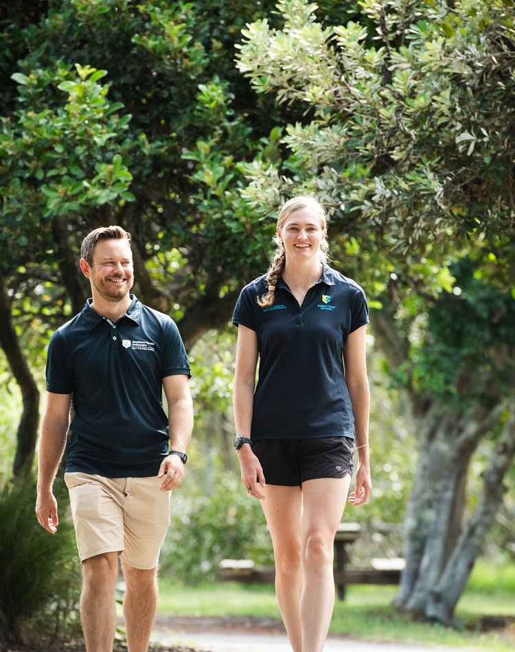 Two people walking through a park