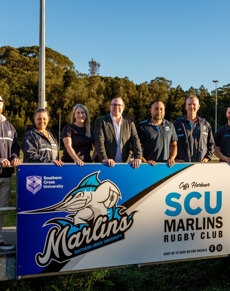 A group of people standing in front of a banner with the words SCU Marlins