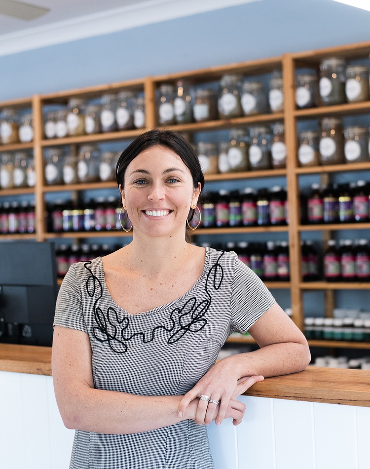 Naturopath stands in front of dispensary counter