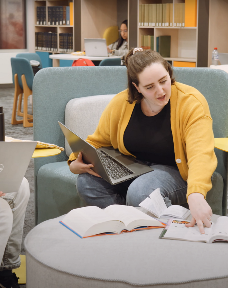 Students sitting in library talking about innovation.