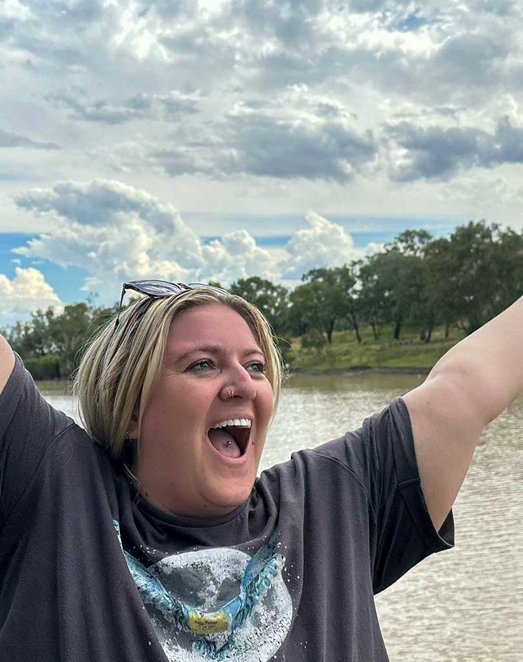 Student in front of brown river