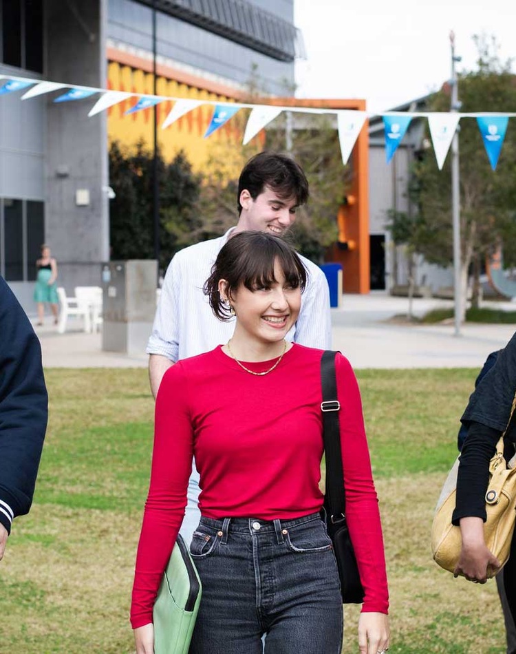 Students walking in grassy field at Gold Coast campus