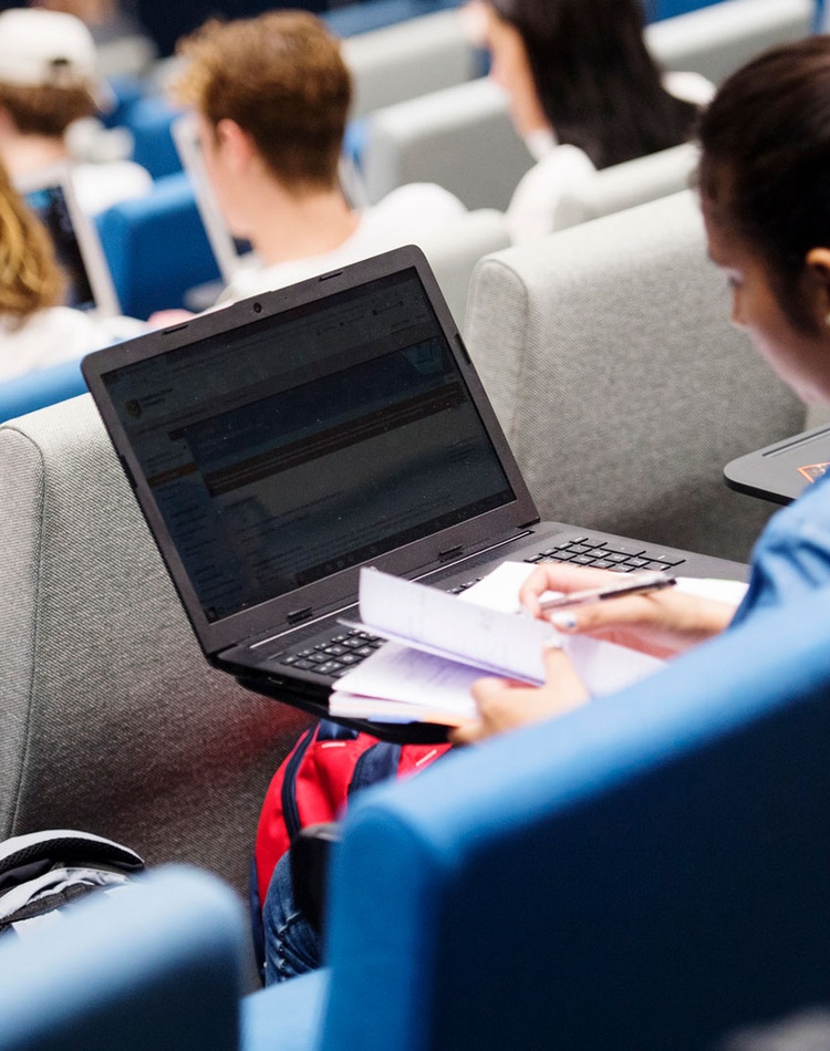 Student in auditorium with laptop