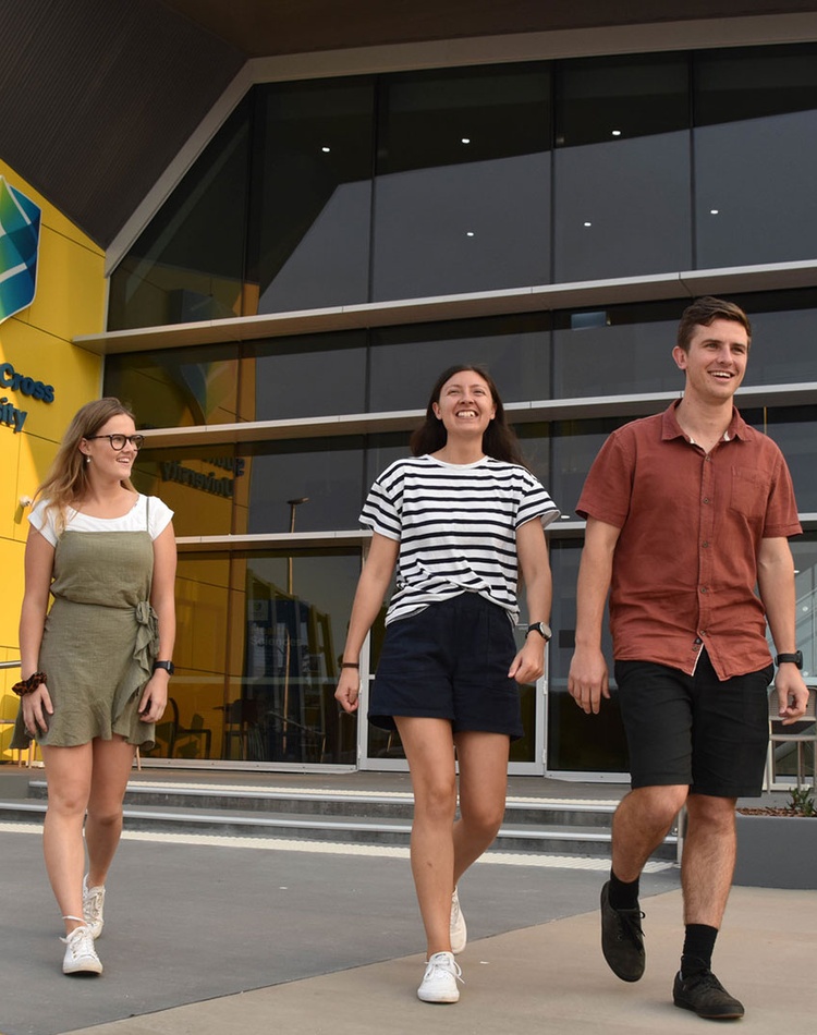 Three students walking outside the Coffs Harbour Health Sciences building