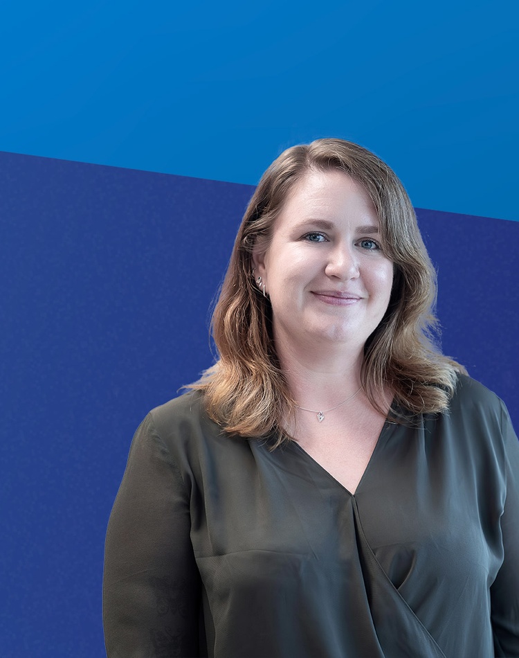 Female student in front of a blue banner