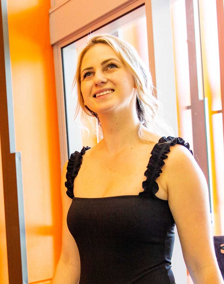 A woman smiling enters a contemporary building