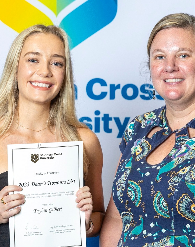 Two women facing the camera, one holding a certificate