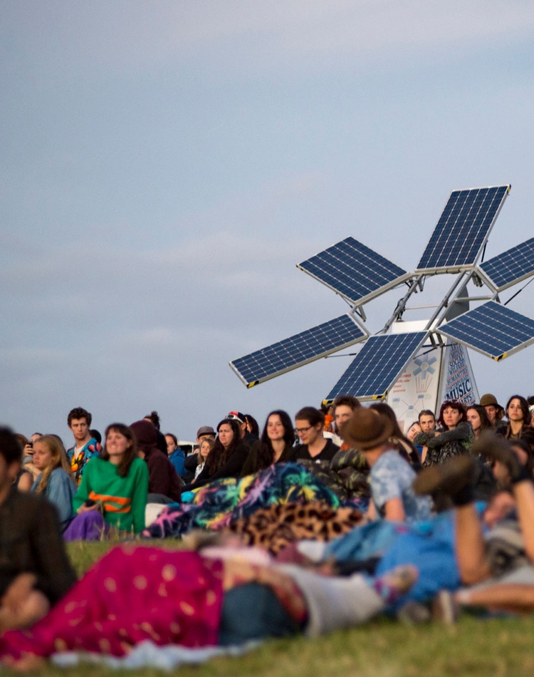 The sunflower solar energy project prototype with a crowd of people attending and event - credit Woodford Folk Festival