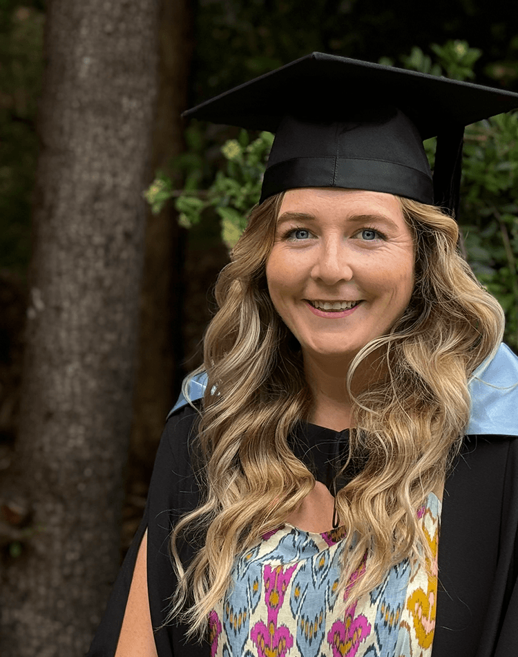 Woman in graduation robes and mortarboard