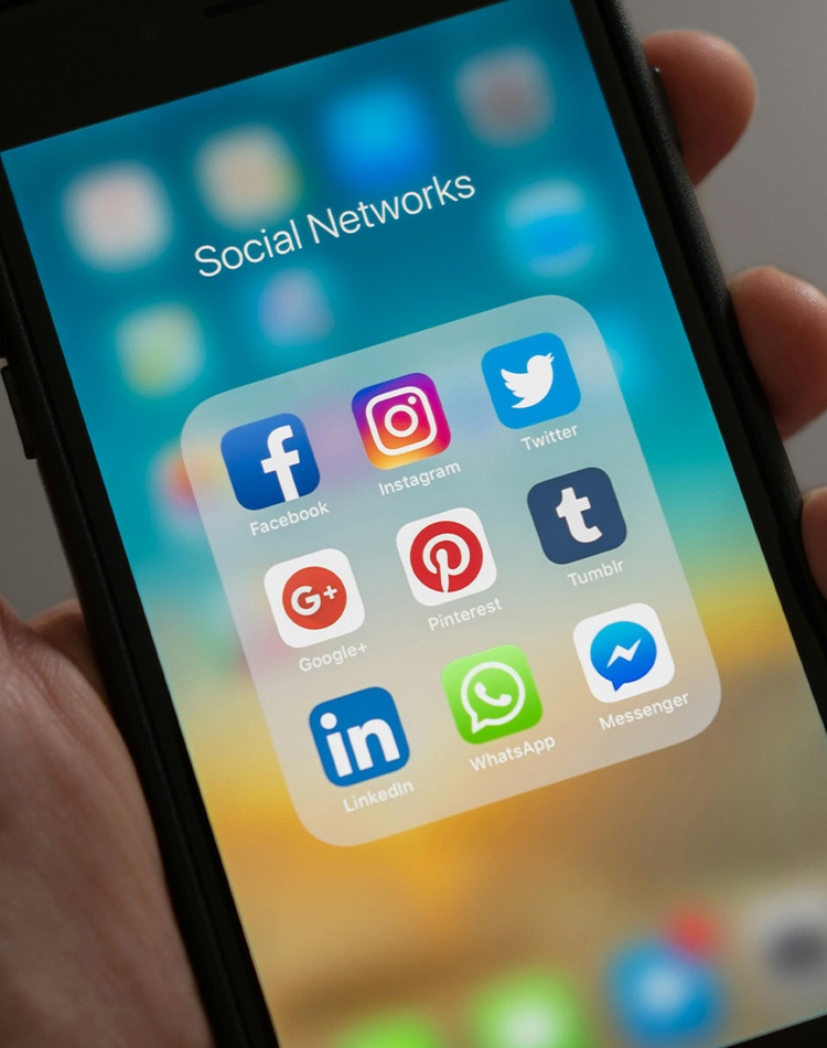 Hand holding phone with social media apps