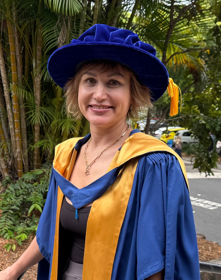 Student in academic robes smiling at camera