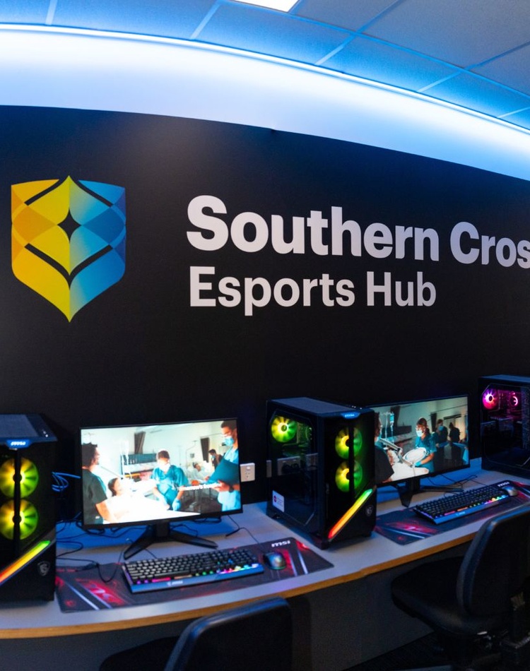 Computers with southern cross branding on black wall above