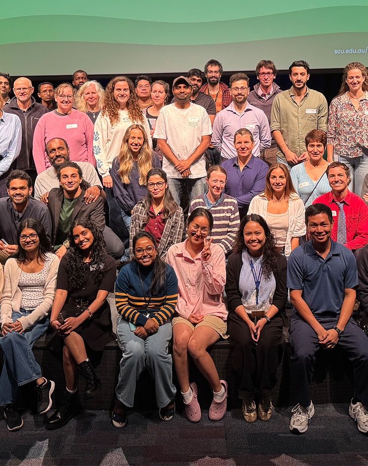 Large group of people smiling on a stage