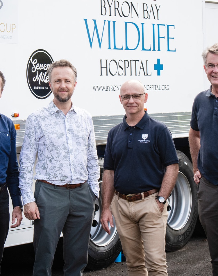 Four people standing in front of Byron Bay Wildlife Hospital van