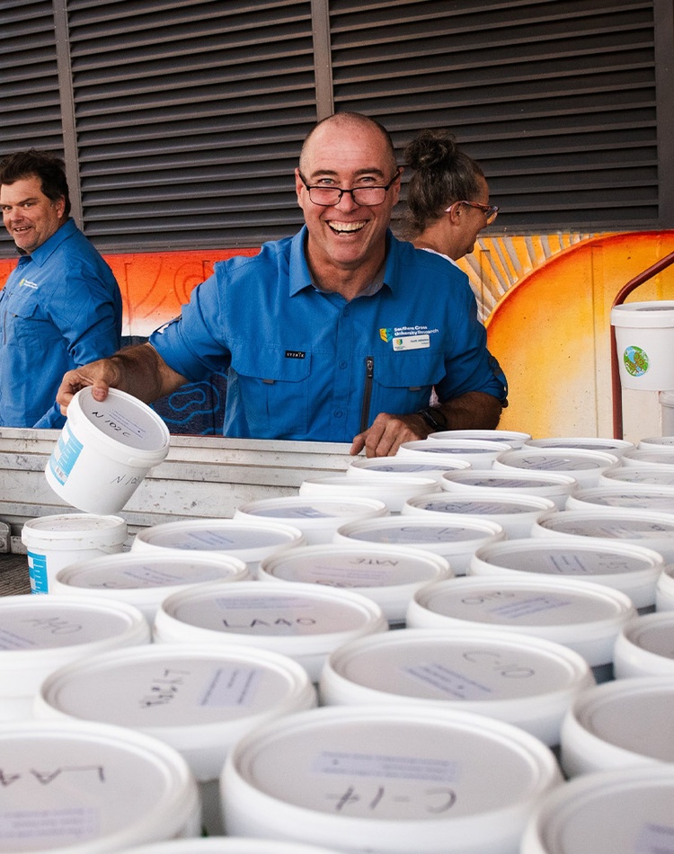 Person smiling in front of buckets