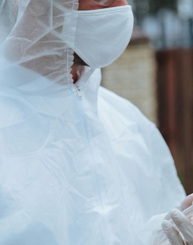Person is PPE holding sample in tube