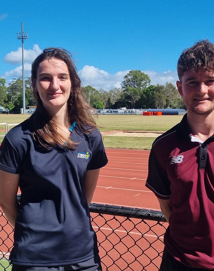 A woman and man standing in front of running track