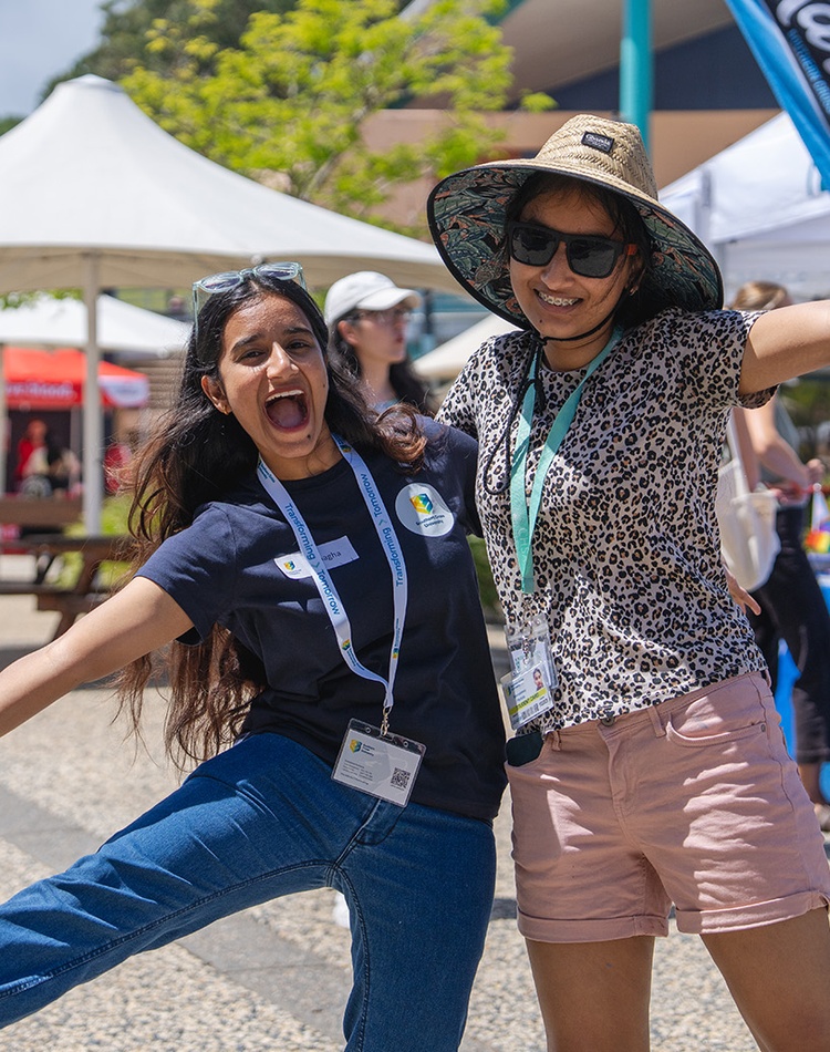 Two people hugging excitedly and smiling at camera