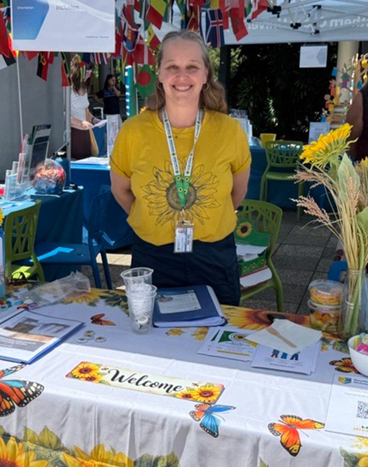 Woman standing at market stall with sunflowers